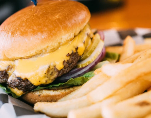Closeup photo of a cheesy burger and fries